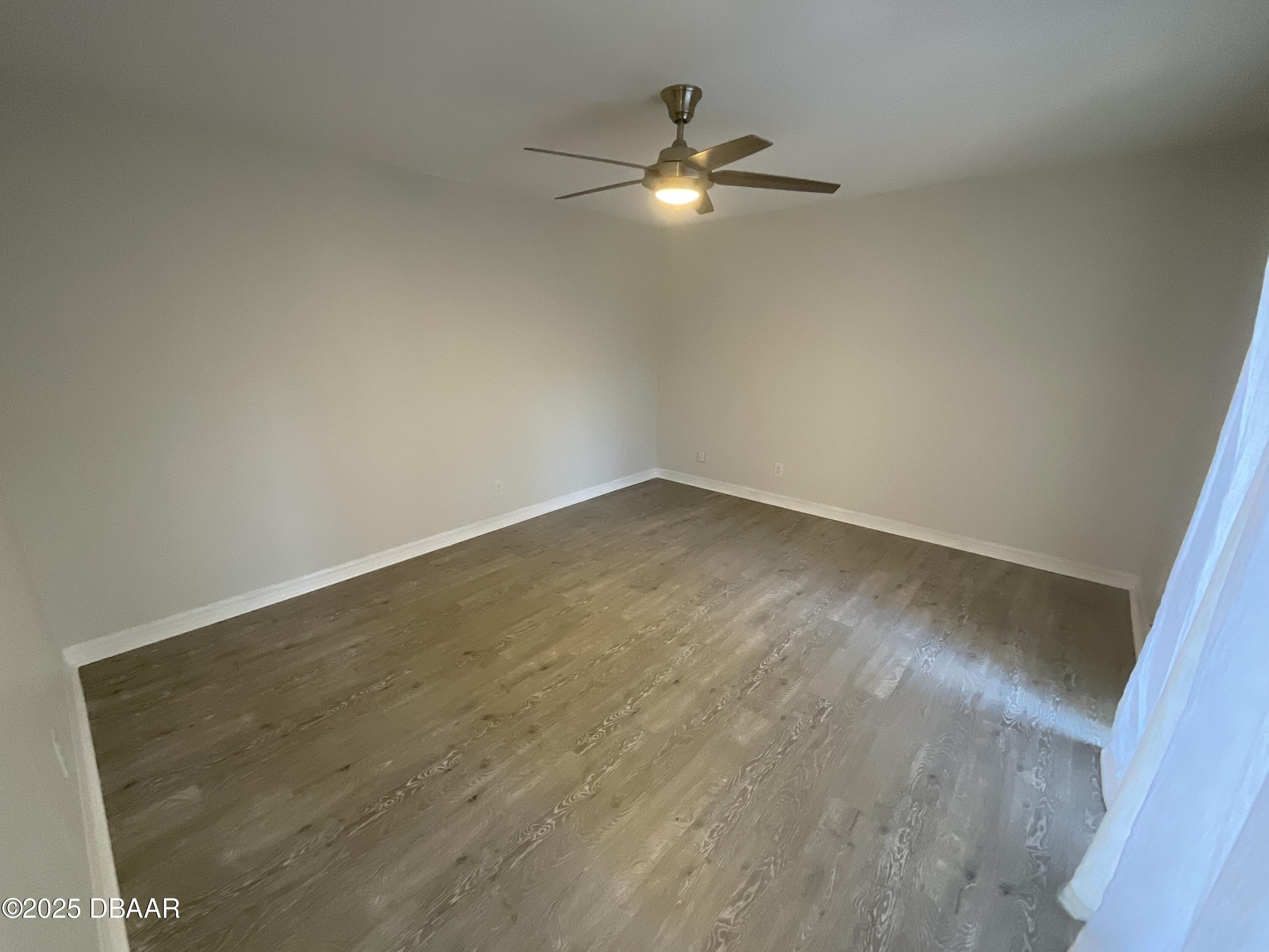 8 Ridge Trail Ormond Beach, FL 32174 - Photo 11 of 24 an empty room with a chandelier fan and wooden floor