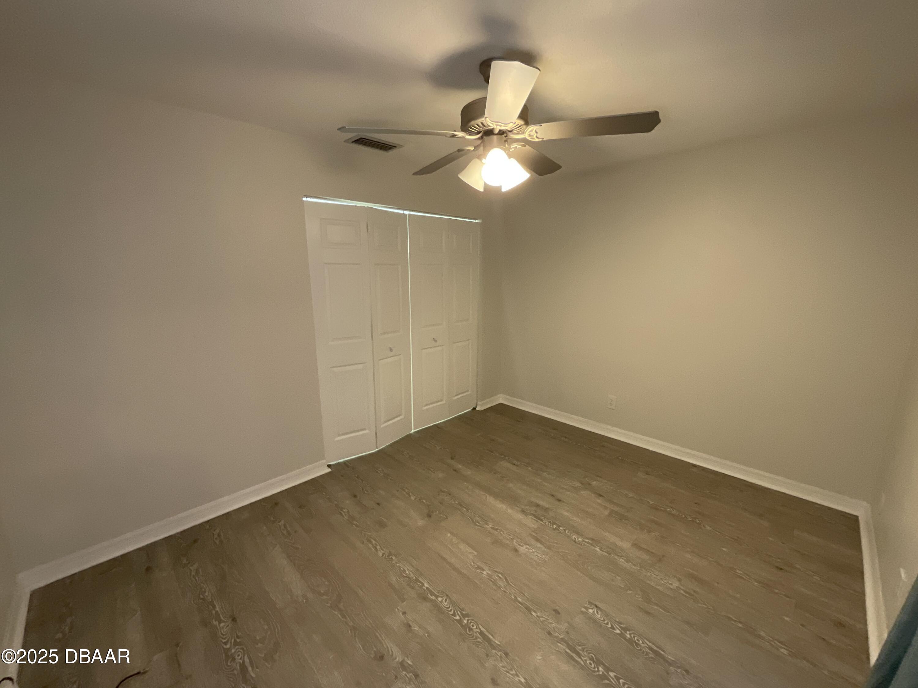8 Ridge Trail Ormond Beach, FL 32174 - Photo 16 of 24 en empty room with wooden floor and fan
