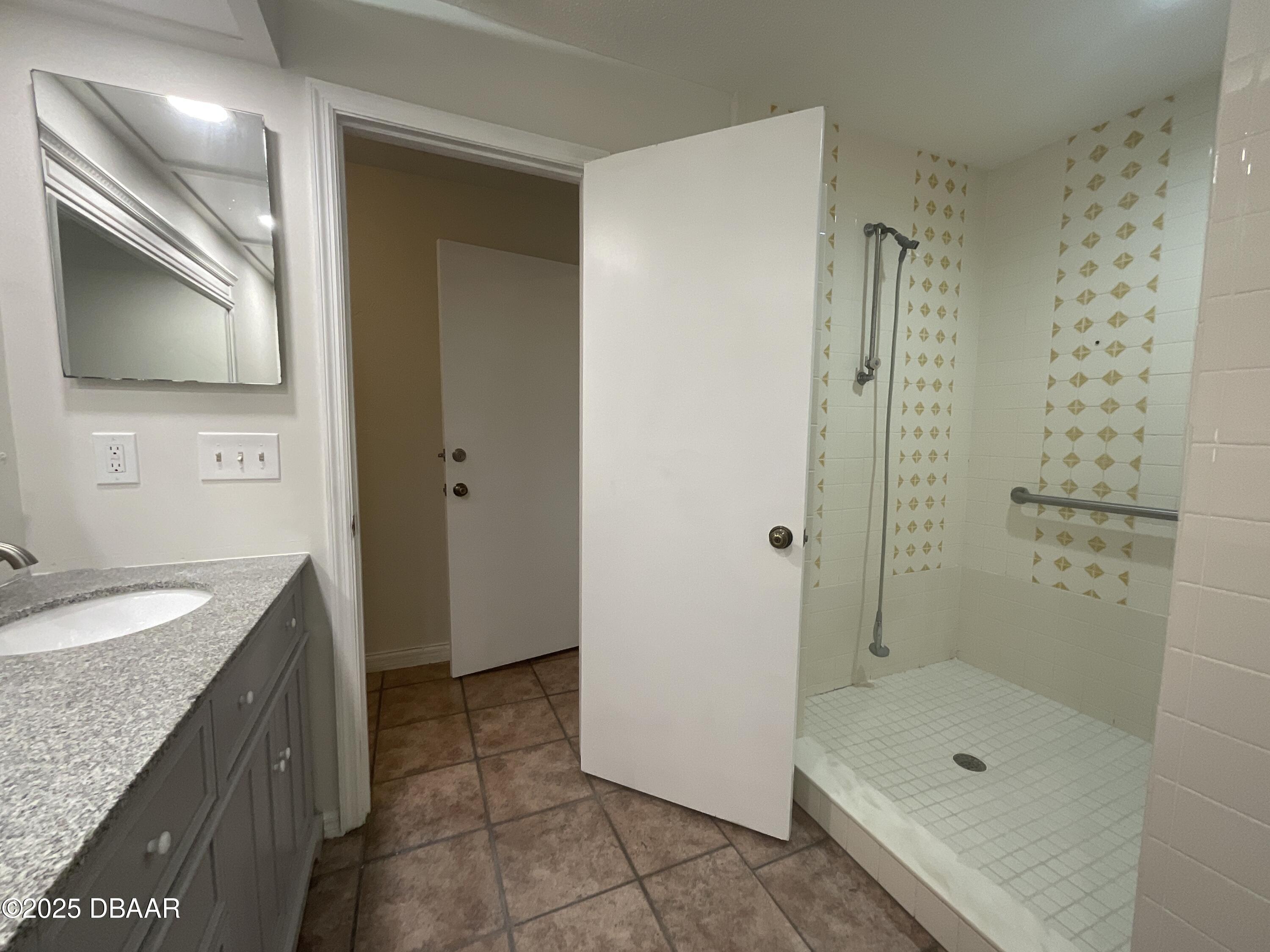 8 Ridge Trail Ormond Beach, FL 32174 - Photo 18 of 24 a bathroom with a granite countertop sink a mirror a bathtub and shower