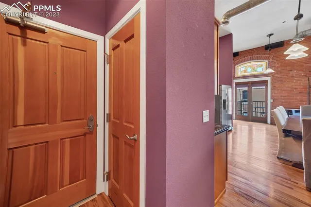 a view of hallway with livingroom and wooden floor