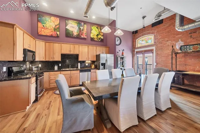 a view of a dining room with furniture a kitchen view and chandelier