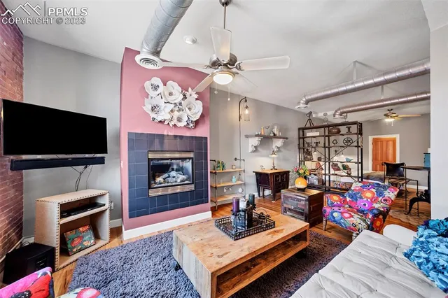 a living room with furniture a flat screen tv and a fireplace