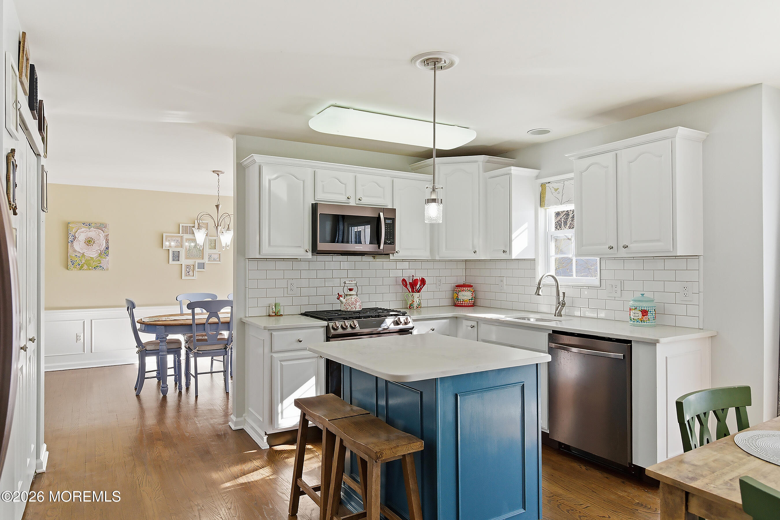 197 Inlet Avenue Manahawkin, NJ 08050 - Photo 10 of 36 a kitchen with a sink stove and white cabinets with wooden floor
