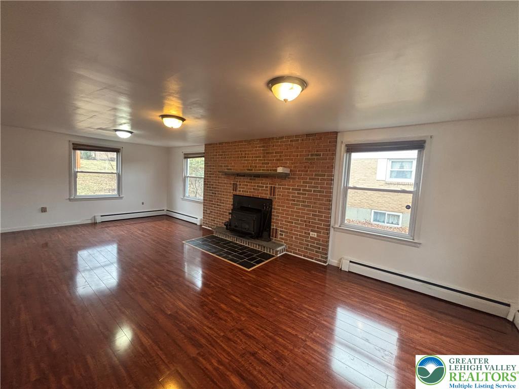 257 East 2nd Street Wind Gap, PA 18091 - Photo 7 of 14 an empty room with wooden floor fireplace and windows