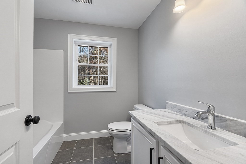 178 French Road, Unit LOT 8 Templeton, MA 01468 - Photo 36 of 39 a bathroom with a granite countertop sink a toilet and a mirror