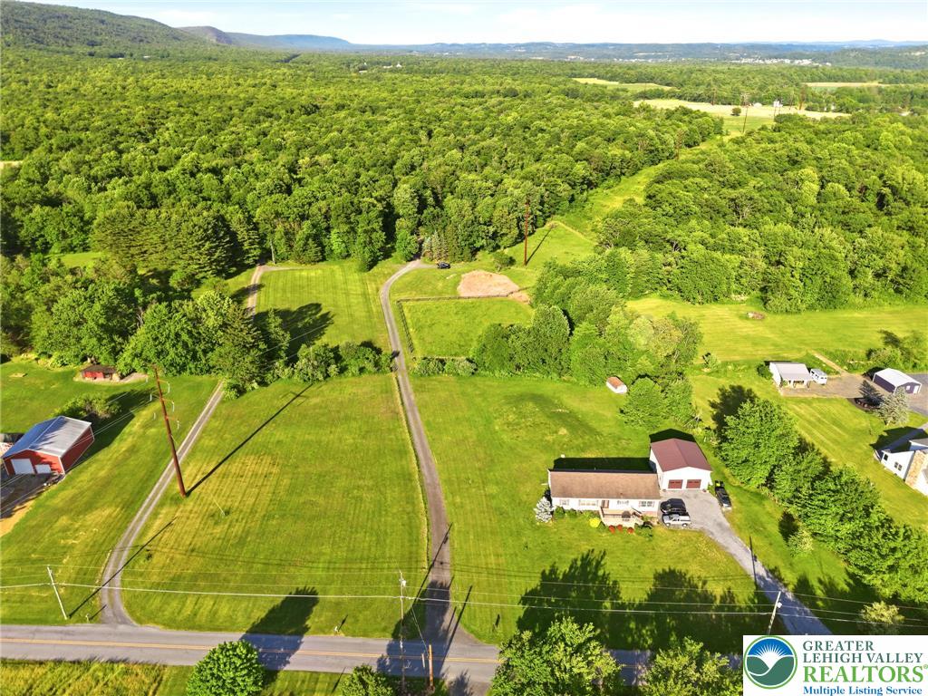 9033 Loop Road Slatington, PA 18080 - Photo 34 of 53 An aerial panorama reveals a vast, verdant estate with rolling hills and a private residence.