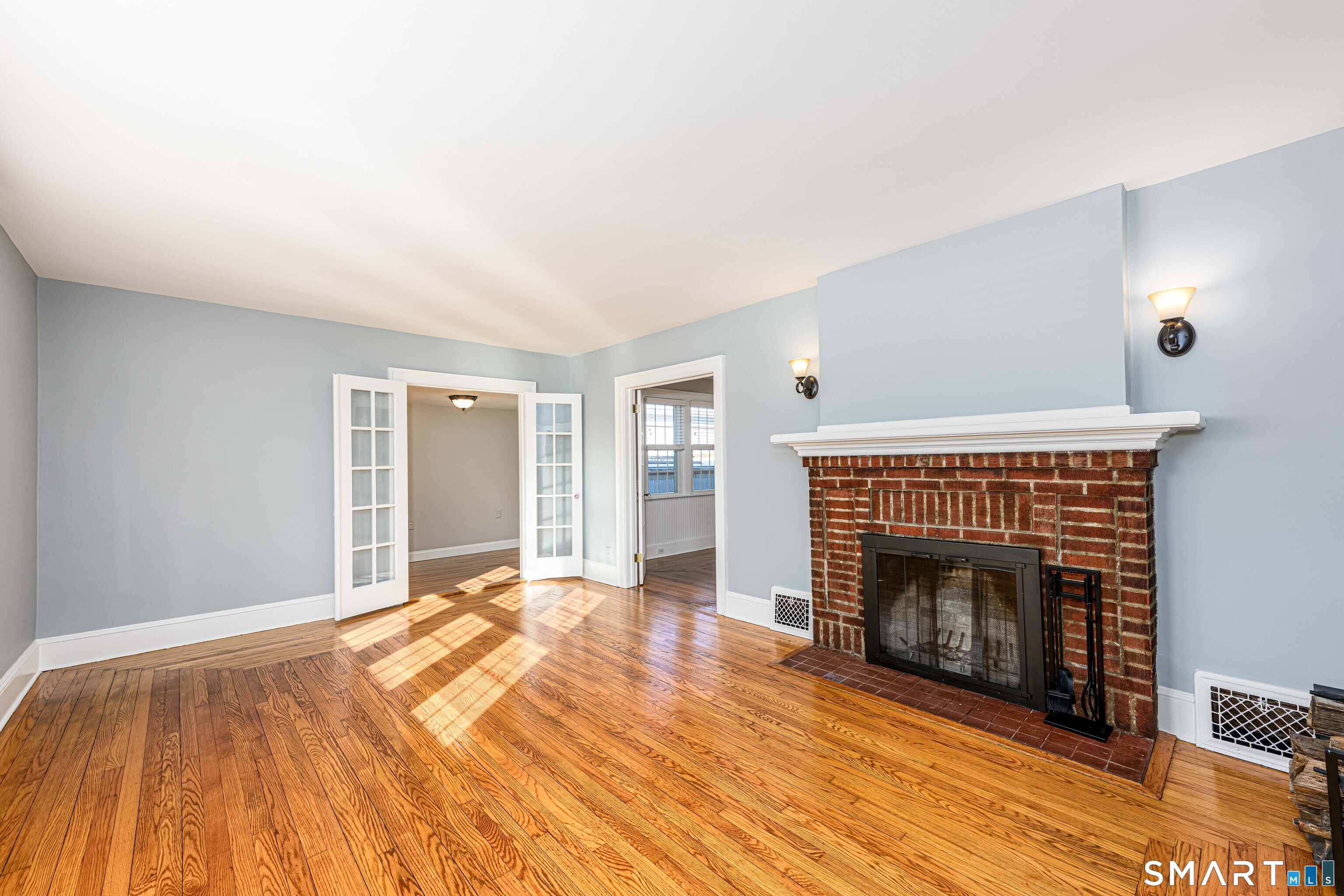 18 Day Spring Avenue Hamden, CT 06518 - Photo 7 of 35 The formal living room is cheerful and bright and offers an attractive wood-burning fireplace. Newly refinished hardwood floors throughout. Two sets of French doors - lead to private office space and full bath, the other to the formal dining room.