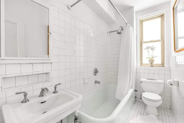 a bedroom with a bed and a dresser next to a window