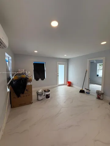 a living room with furniture a flat screen tv and gym equipment