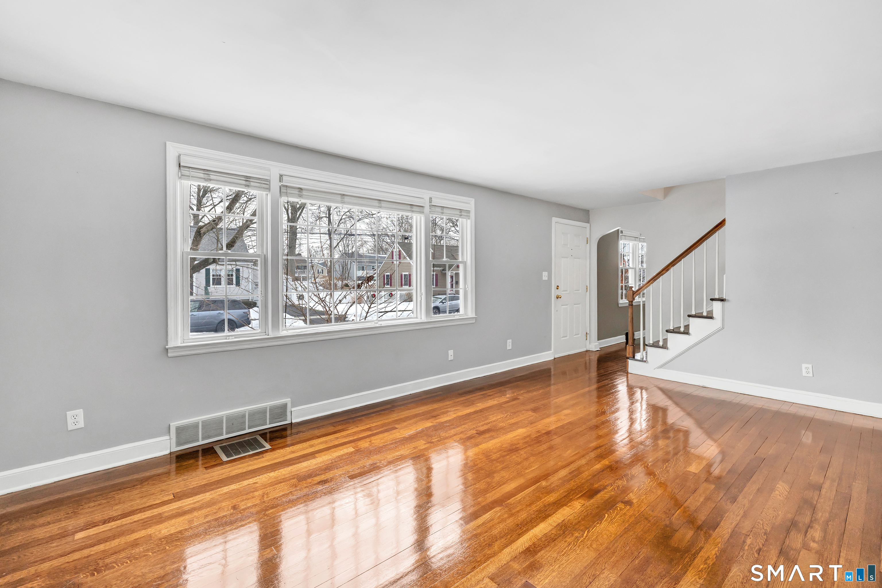 115 Spring Street Stratford, CT 06614 - Photo 22 of 26 a view of an empty room with window and wooden floor