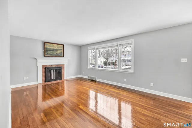 a view of a livingroom with wooden floor and a fireplace