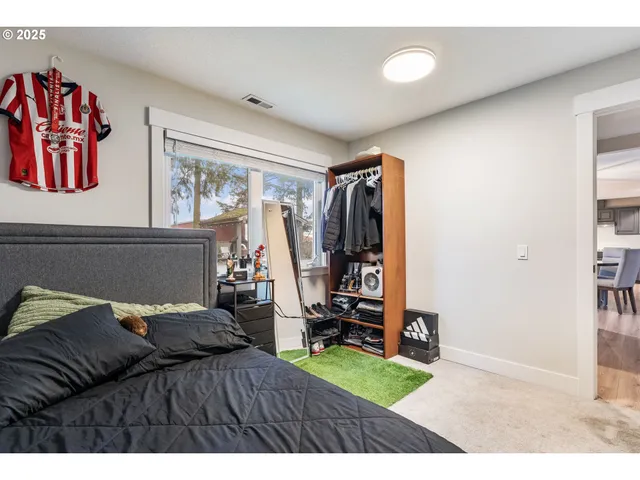 a bedroom with a bed and a view of living room