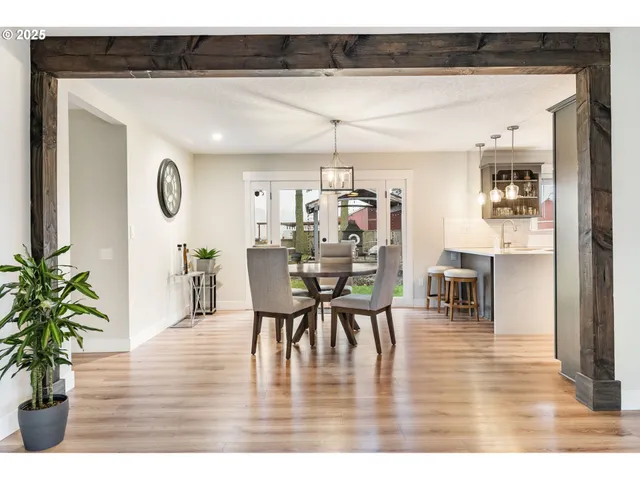 a dining room with furniture potted plants and wooden floor