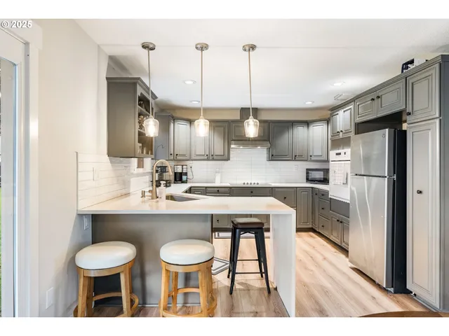 a kitchen with kitchen island a sink stove and refrigerator