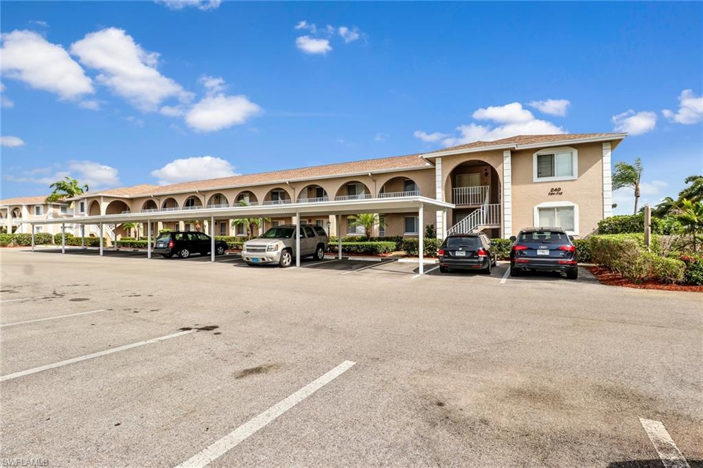 240 Pebble Beach Boulevard, Unit 710 Naples, FL 34113 - Photo 3 of 26 a group of cars parked in front of a building