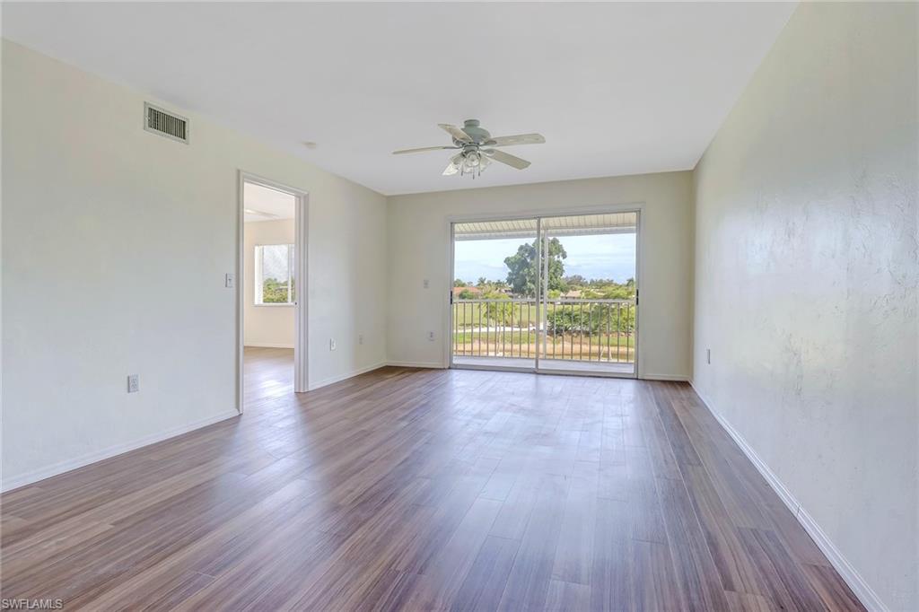 240 Pebble Beach Boulevard, Unit 710 Naples, FL 34113 - Photo 6 of 26 wooden floor in an empty room with a window