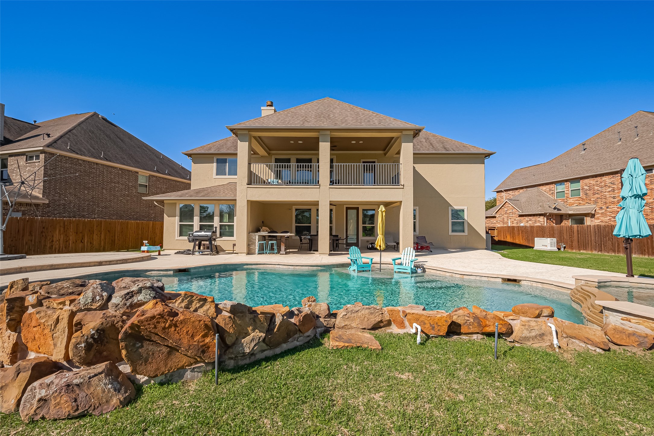 Luxurious backyard oasis with a stunning pool and spacious covered patio—perfect for relaxation and entertainment.