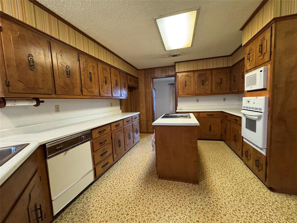 209 Harrison Avenue Roxton, TX 75477 - Photo 12 of 18 a kitchen with stainless steel appliances granite countertop a sink a stove and a refrigerator