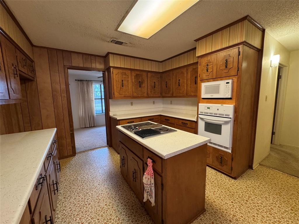 209 Harrison Avenue Roxton, TX 75477 - Photo 13 of 18 a kitchen with a stove and a refrigerator