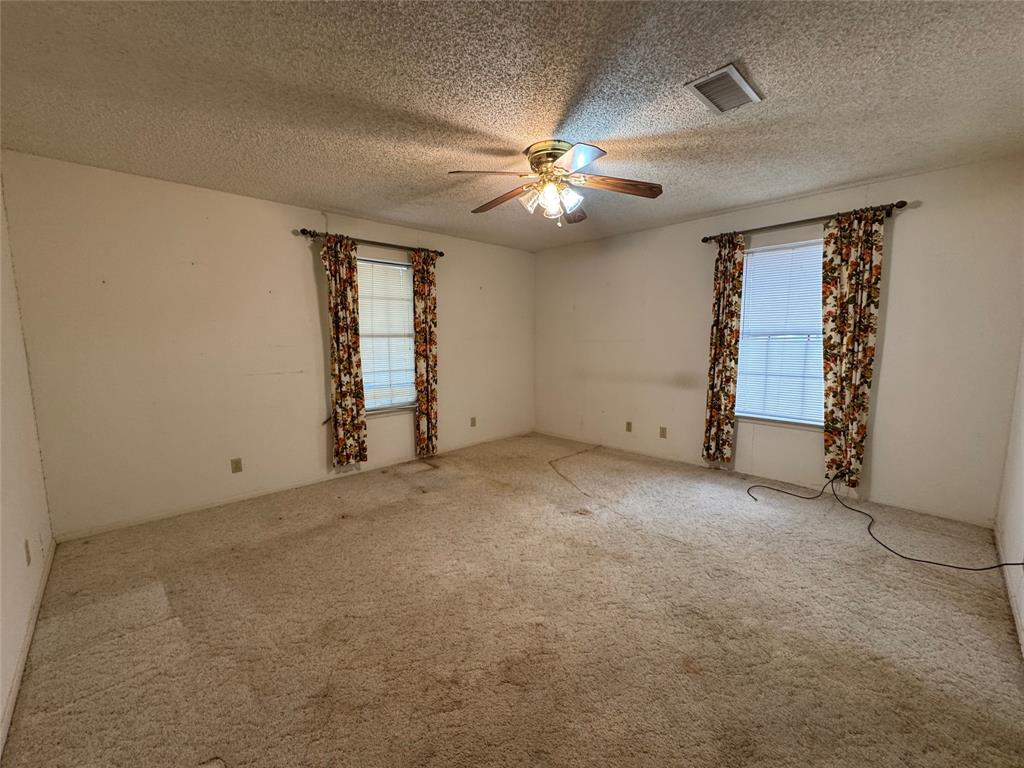 209 Harrison Avenue Roxton, TX 75477 - Photo 15 of 18 an empty room with windows and fan