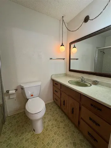 a bathroom with a granite countertop toilet sink and mirror