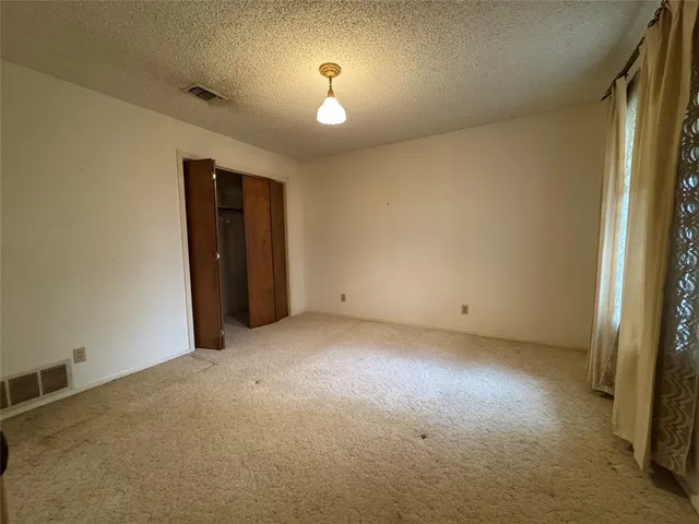an empty room with closet and windows