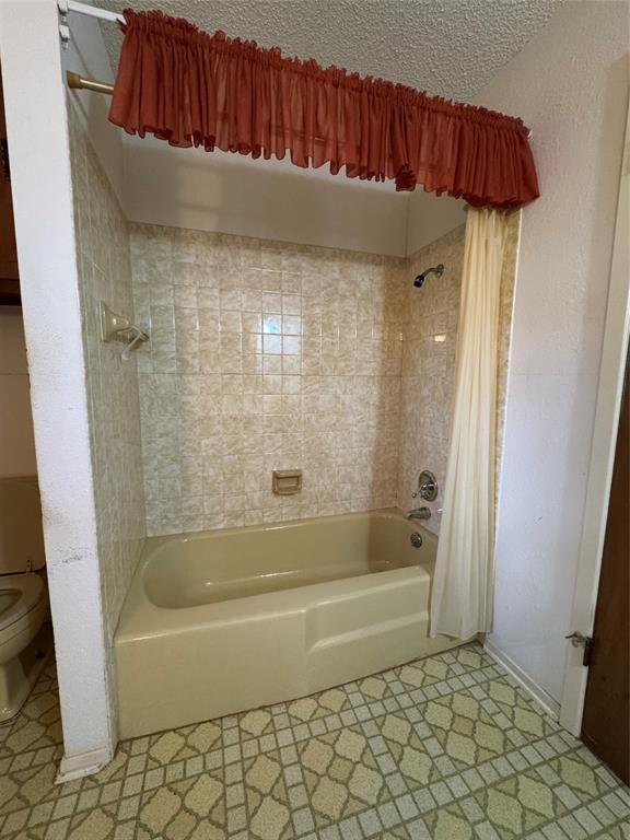 209 Harrison Avenue Roxton, TX 75477 - Photo 10 of 18 a bathroom with a bathtub and a shower