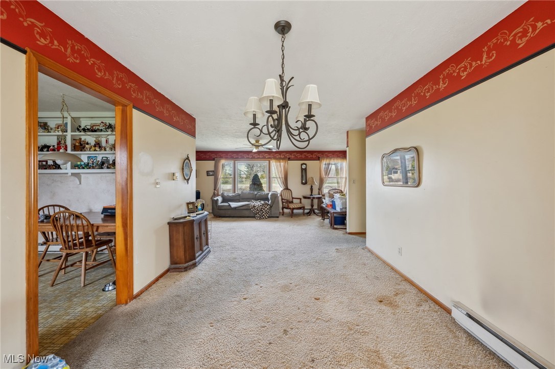 4790 Paradise Road Seville, OH 44273 - Photo 22 of 45 Hallway featuring baseboards, carpet floors, an inviting chandelier, and a baseboard radiator
