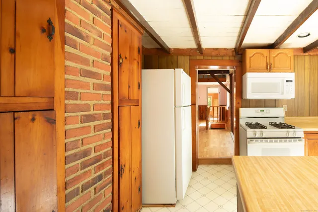 a view of a kitchen with refrigerator and a stove
