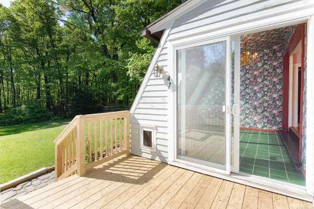 a view of a balcony with a floor to ceiling window and wooden fence