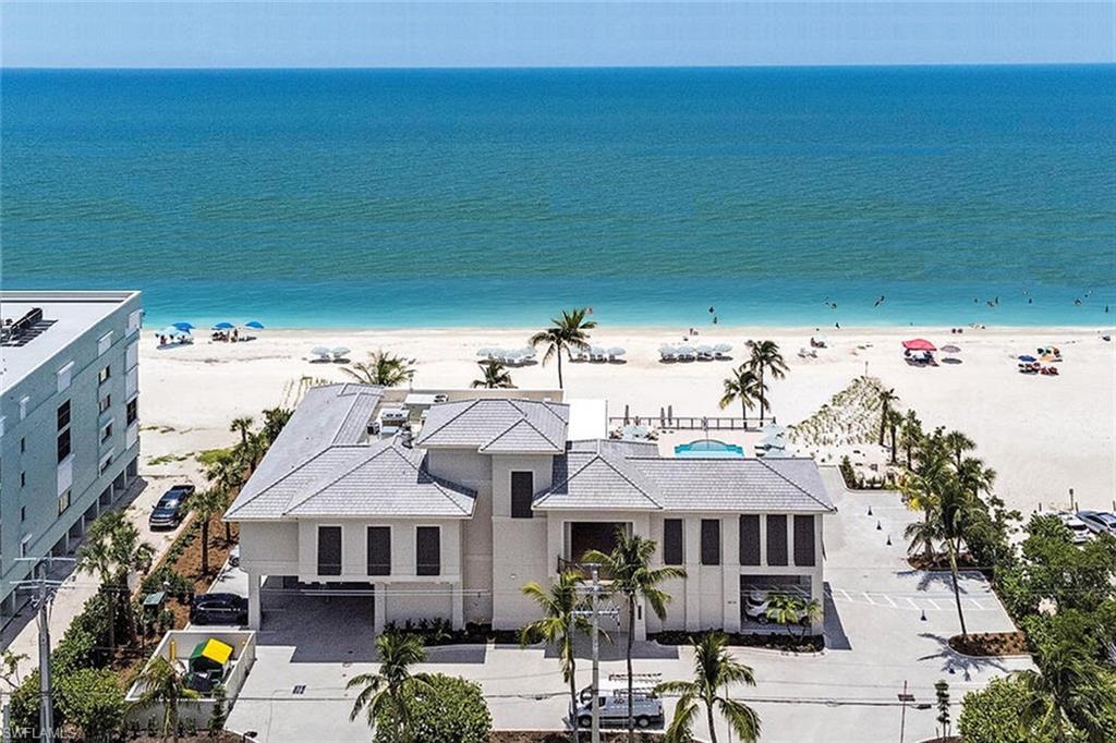 17015 Porta Vecchio Way, Unit 101 Naples, FL 34110 - Photo 34 of 39 a view of a big house with pool and chairs