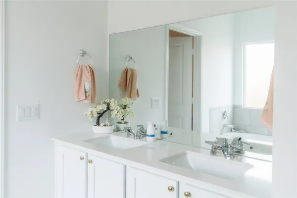 a bathroom with double vanity sinks and a mirror