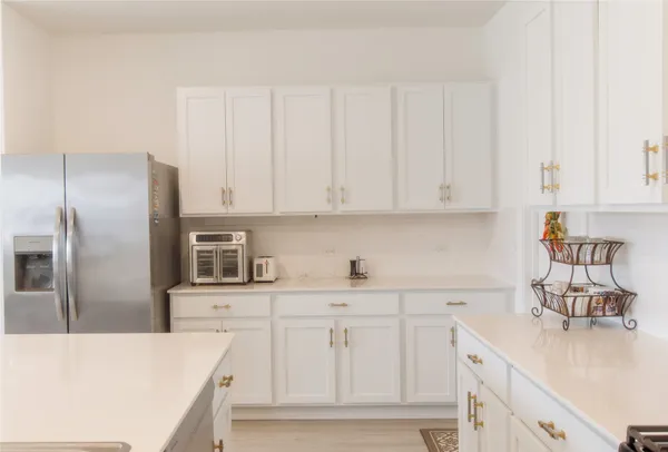 a kitchen with white cabinets and stainless steel appliances