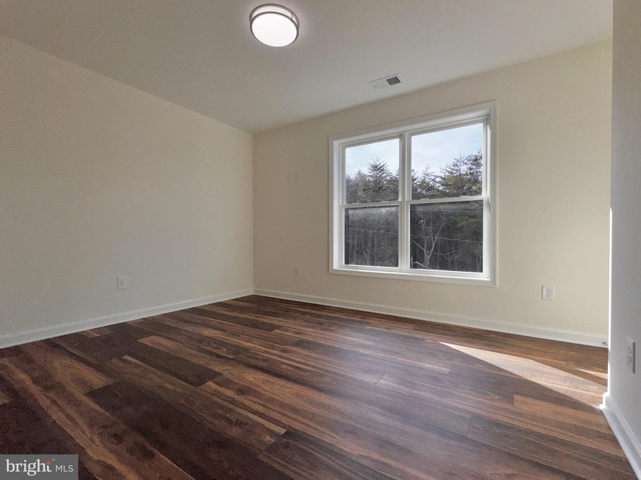 1241 Pine Grove Road Berkeley Springs, WV 25411 - Photo 15 of 19 a view of an empty room with wooden floor and a window