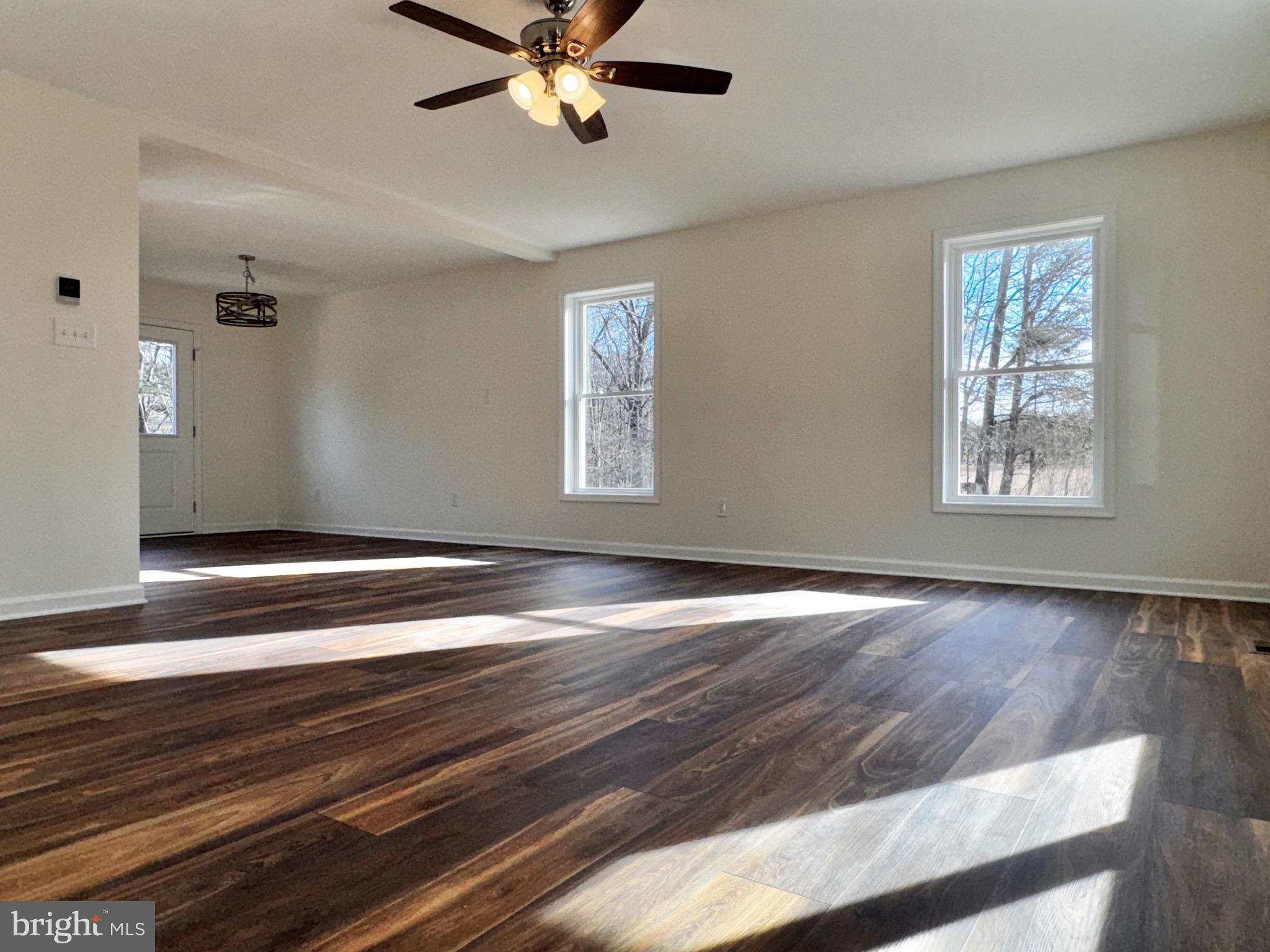 1241 Pine Grove Road Berkeley Springs, WV 25411 - Photo 3 of 19 a view of empty room with wooden floor and fan