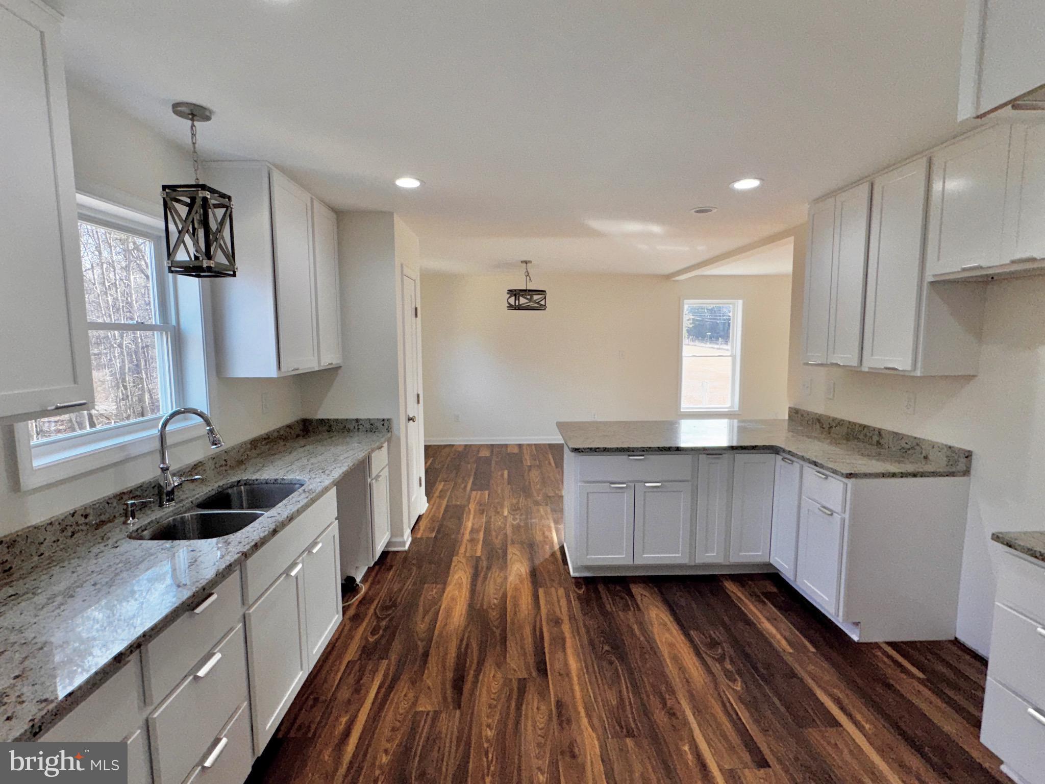 1241 Pine Grove Road Berkeley Springs, WV 25411 - Photo 4 of 19 a kitchen with granite countertop wooden cabinets a sink and dishwasher