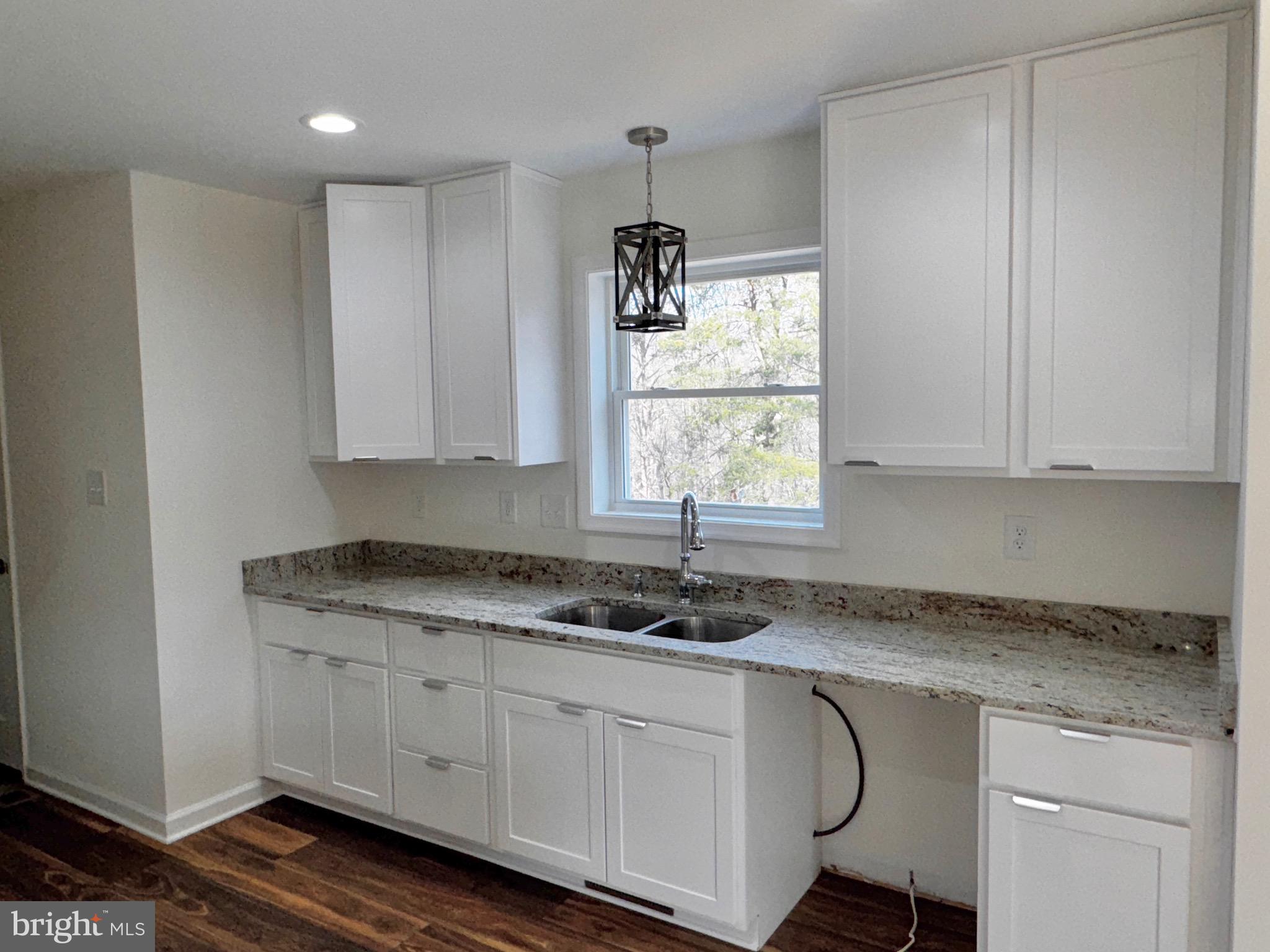 1241 Pine Grove Road Berkeley Springs, WV 25411 - Photo 5 of 19 a kitchen with granite countertop white cabinets white appliances and a granite counter tops