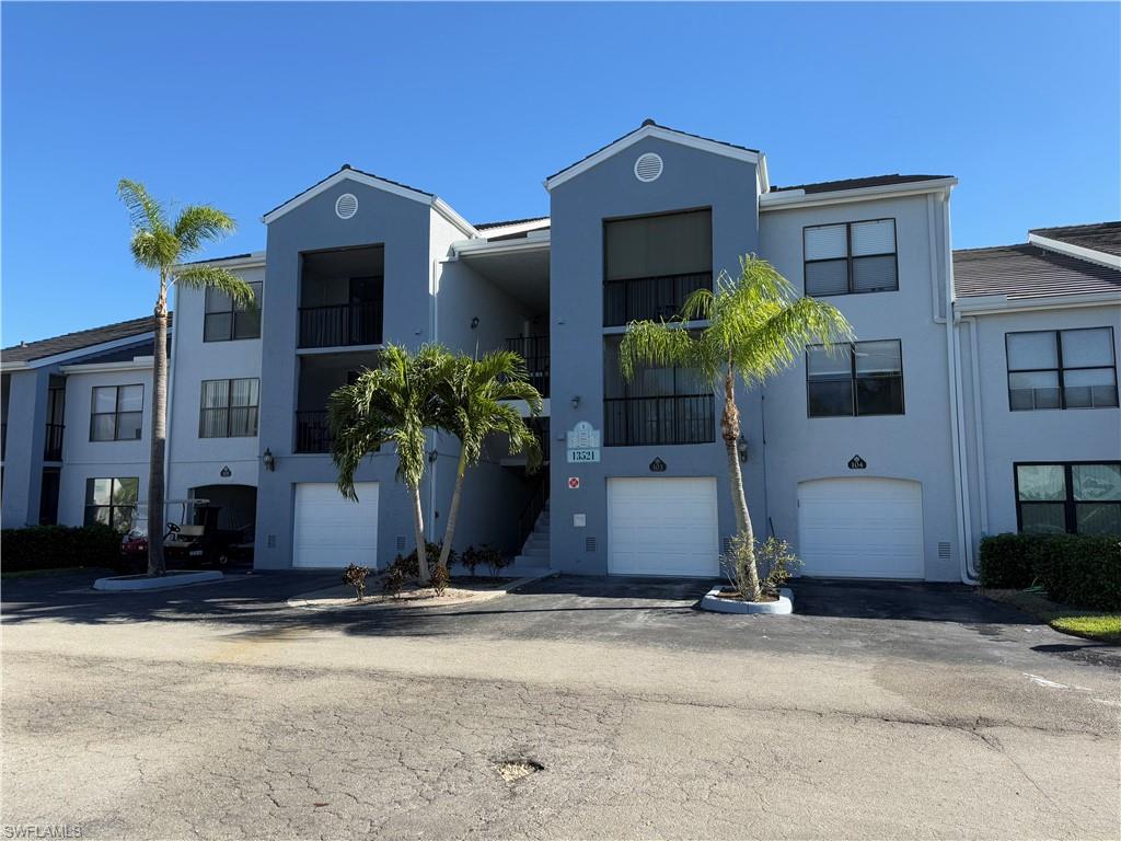 13521 Eagle Ridge Drive, Unit 133 Fort Myers, FL 33912 - Photo 1 of 15 a front view of a house with a yard and a garage