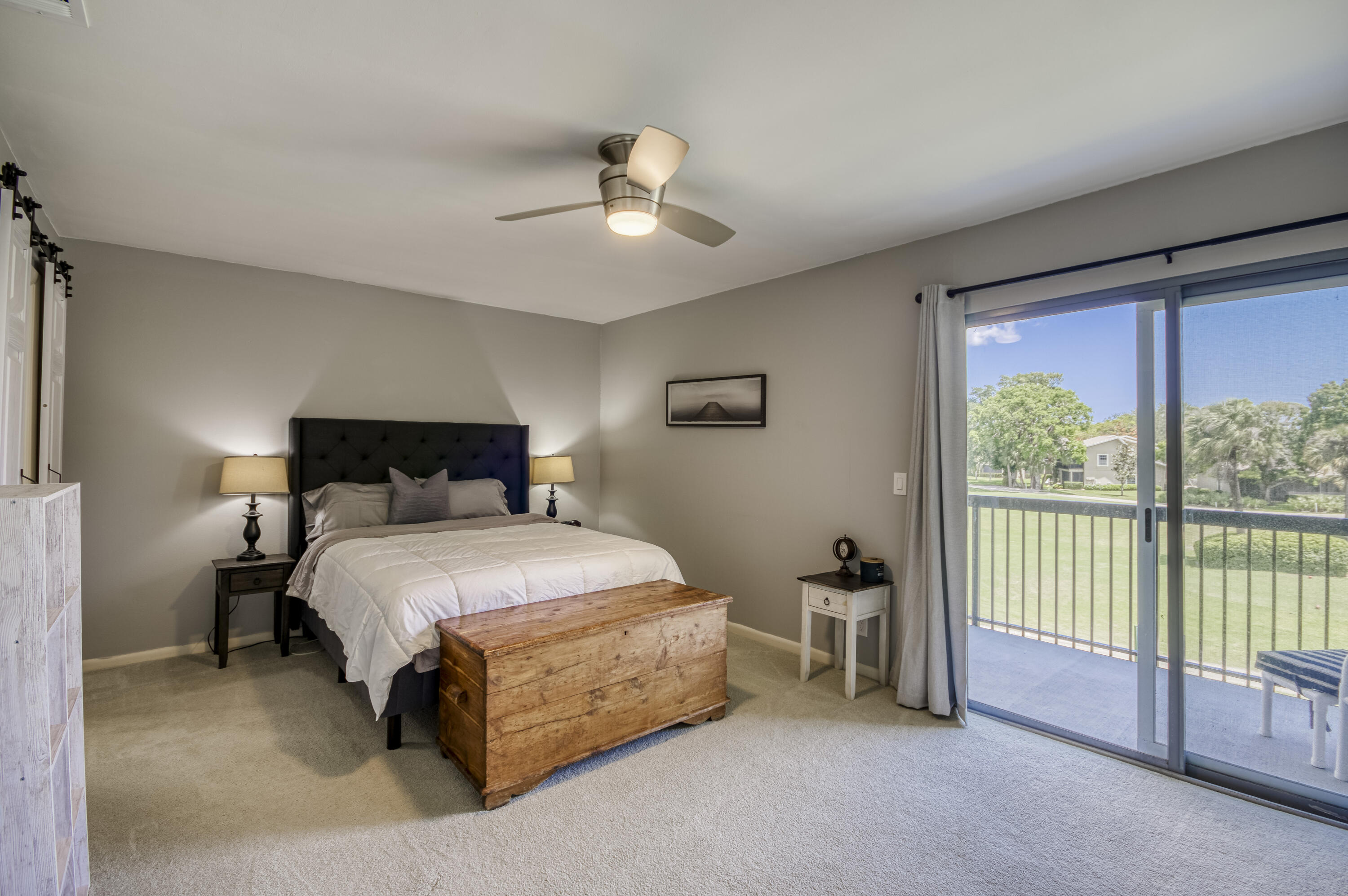 9239 Southeast Riverfront Terrace, Unit D Jupiter, FL 33469 - Photo 15 of 33 a spacious bedroom with a bed and a chandelier