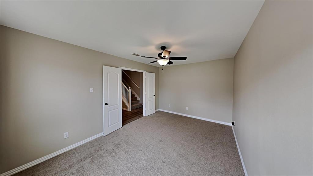 2203 Wagon Wheel Trail Corinth, TX 76208 - Photo 11 of 16 an empty room with a ceiling fan and a window