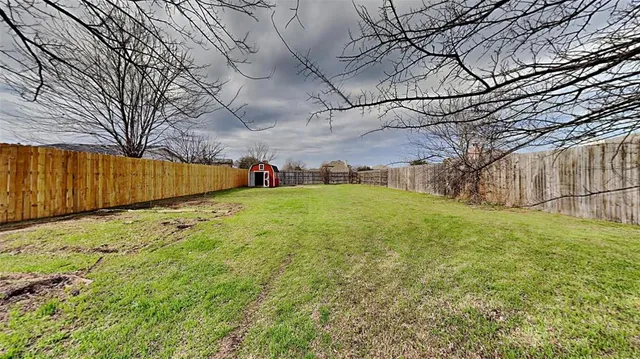 a view of a yard with wooden fence