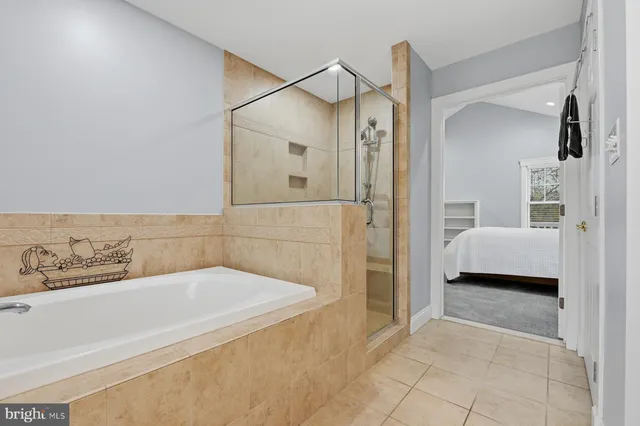 a spacious bedroom with a bed a dresser and a window