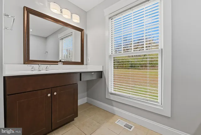 a bathroom with a sink vanity and a mirror
