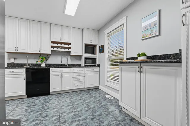 a kitchen with stainless steel appliances granite countertop a refrigerator a stove and a sink