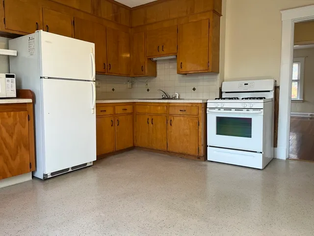a kitchen with granite countertop cabinets stainless steel appliances and a counter space