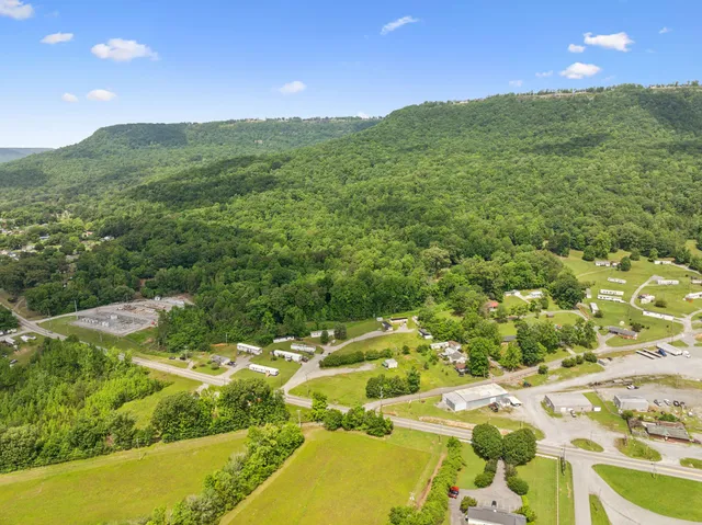 an aerial view of residential house with outdoor space and trees all around