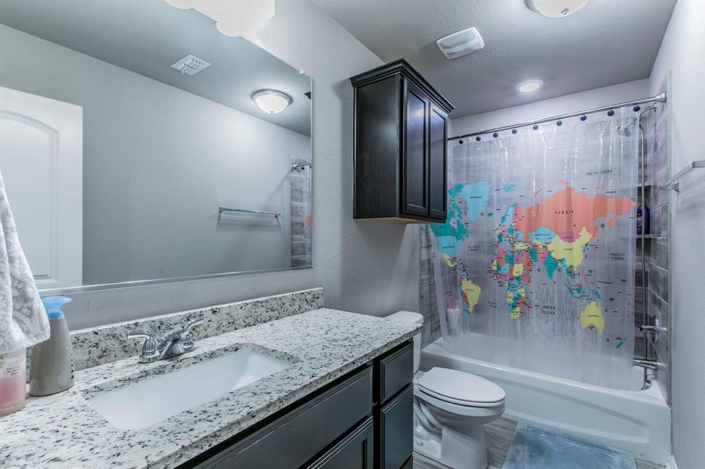3113 Samson Drive Lorena, TX 76655 - Photo 17 of 25 a bathroom with a granite countertop sink a toilet and shower