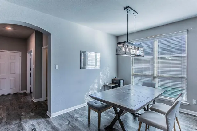 a view of a dining room with furniture a chandelier and wooden floor