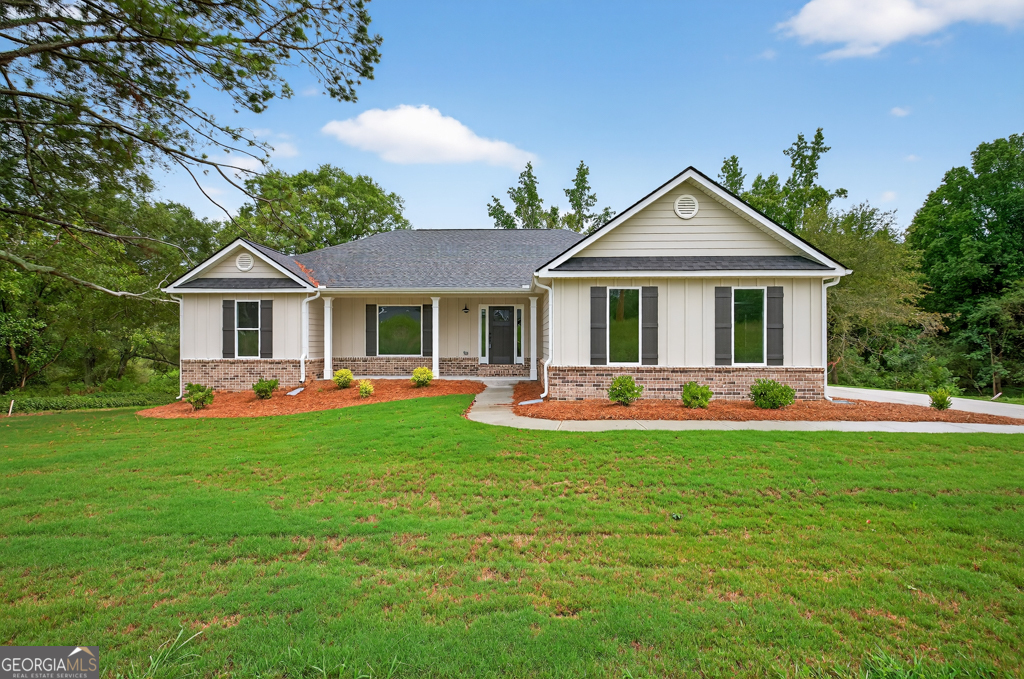 a front view of a house with a yard and trees