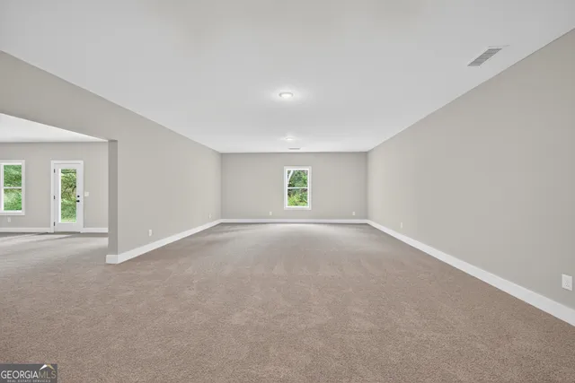 a view of a big room with windows and chandelier fan
